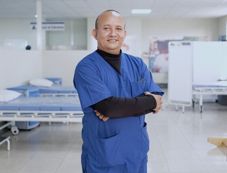 Hombre con bata médica y brazo en cabestrillo